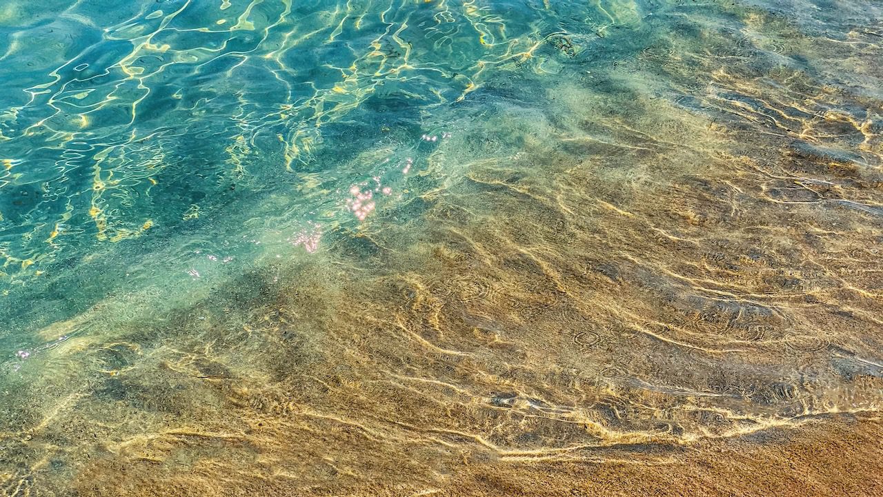 Crystal-clear waters washing over the sandy shores of Nissi Beach, highlighting the natural beauty of the Mediterranean Sea.