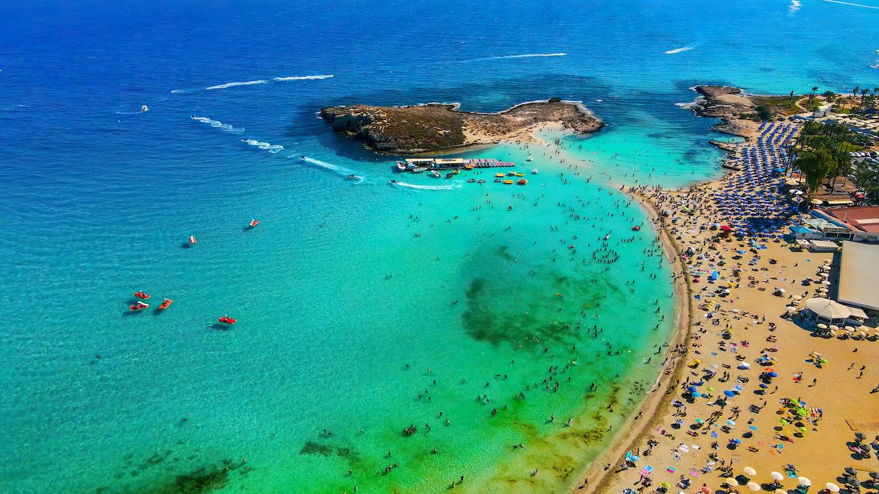Aerial view of Nissi Beach in Ayia Napa, Cyprus, showcasing the beach's turquoise waters and lively atmosphere.