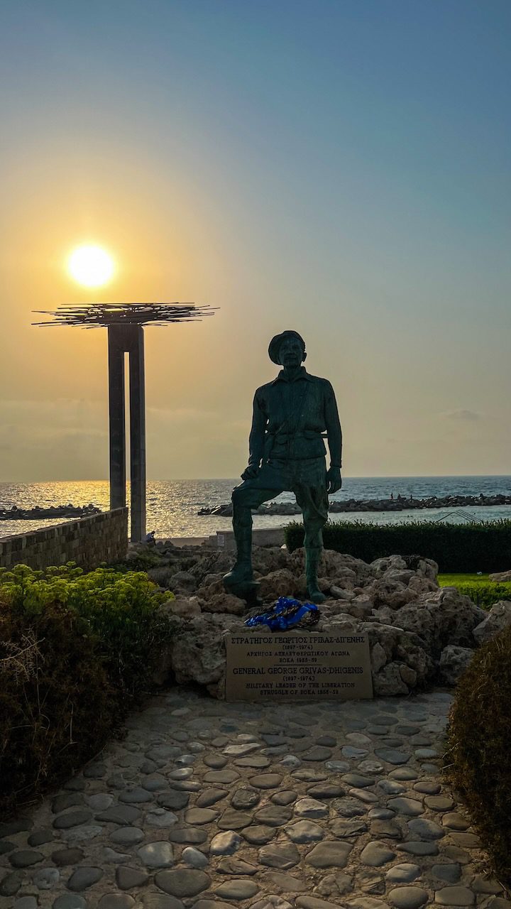 Statue of General Grivas Digenis standing against the setting sun in Chloraka, Cyprus, commemorating his role in the nation's history.