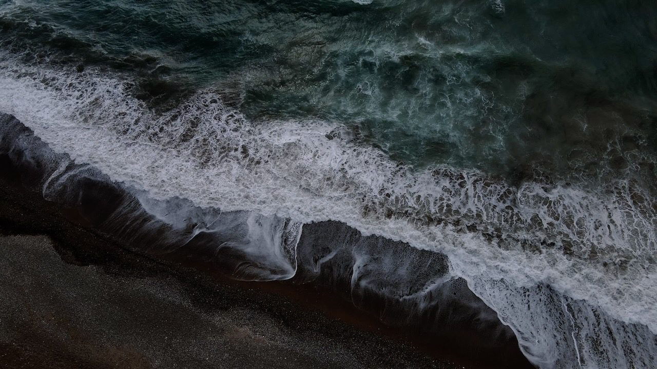 Dark, foamy waves crashing on Paphos coast on a cloudy, windy day.